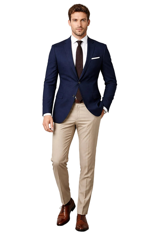 Man wearing a navy blazer, beige pants, and brown shoes against a white background