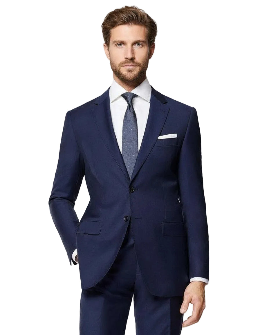 Man wearing a navy suit with a white shirt and blue tie on a light gray background