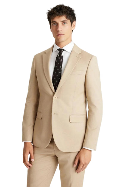 Man wearing a beige suit with a white shirt and patterned tie on a light gray background