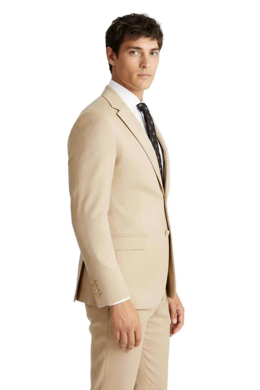Man wearing a beige suit with a white shirt and black tie on a light gray background